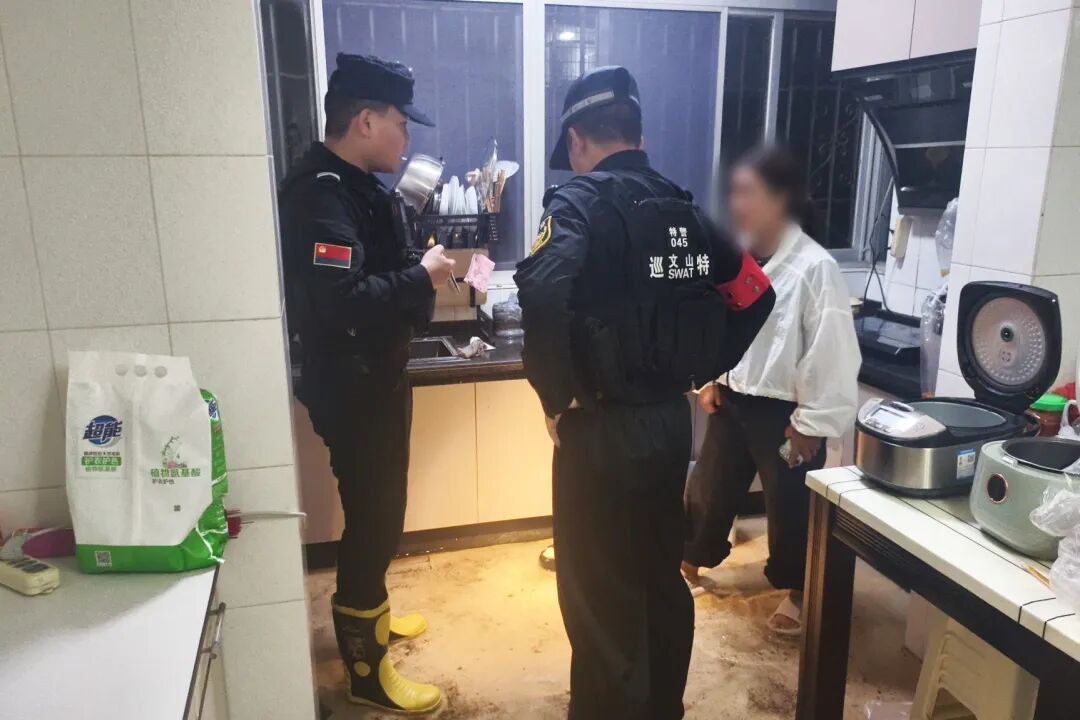 文山一群众家中因暴雨被淹、家中断电,特巡警第一时间前往现场开展救助(2)。.jpg